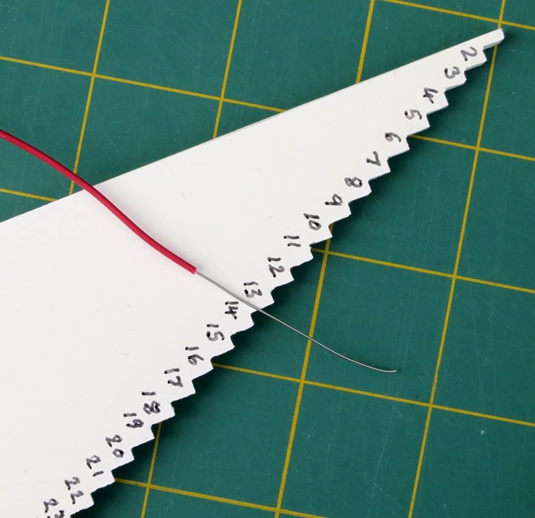 A homemade wire-length gauge for breadboard jumper wires.