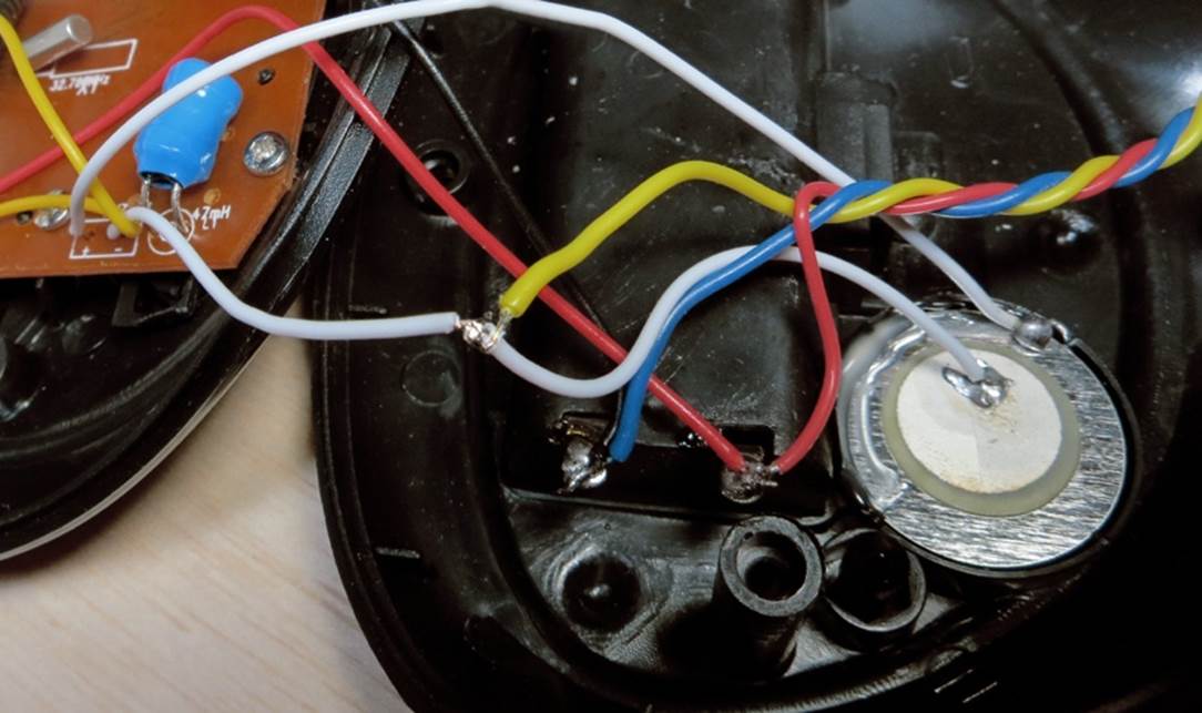 The yellow wire is attached to the existing white wire connecting with the low side of the beeper inside the alarm clock. The blue and red wires have been attached to the battery carrier.